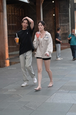 街拍手拿果汁饮料的美腿小姐姐