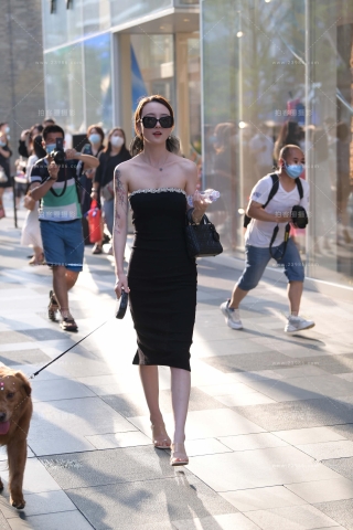 街拍养狗狗的时尚抹胸裙美女