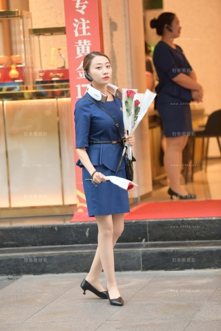 抓拍送玫瑰花的金店促销员